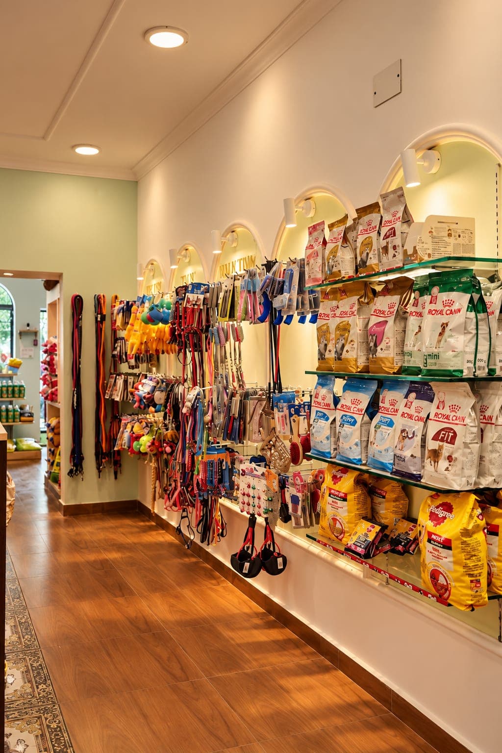 The supplies aisle: walls of leashes, toys and pet food under arched lights
