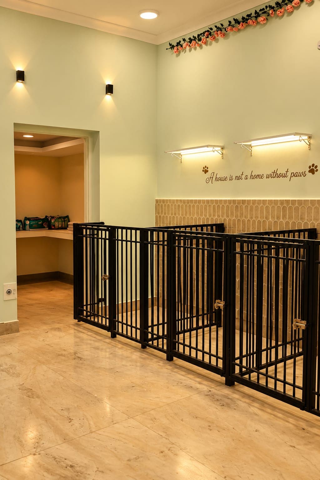 The hostel: rows of gated suites under a wall that reads ‘A house is not a home without paws’